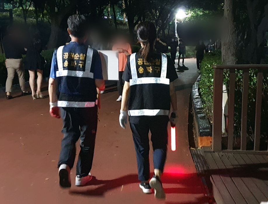 지난 6일 오후 10시부터 서울 송파구 석촌호수에서 이 호수 관리사무소 직원 2명이 신종 코로나바이러스 감염증(코로나19) 확산 차단을 위한 공원 내 음주 금지 계도를 하고 있다. 김지헌 기자