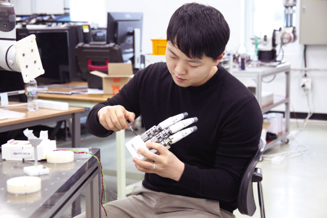 기계연 연구원이 인간형로봇 손을 점검하고 있다.[한국기계연구원 제공]