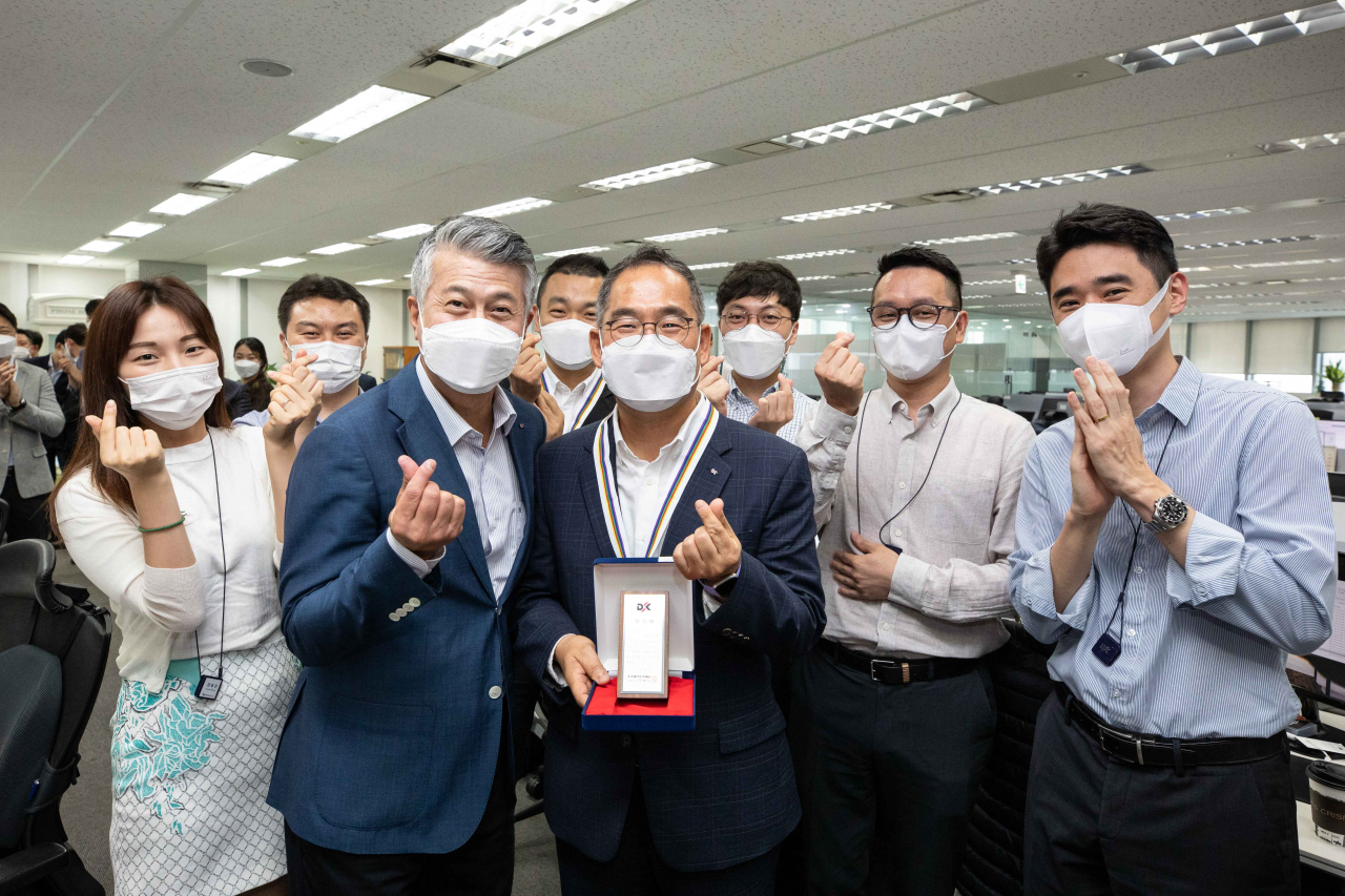 동국제강 본사에서 열린 창립 67주년 행사에서 장세욱 동국제강 부회장(가운데에서 왼쪽)과 25년 장기근속상을 수상한 김의진 동국제강 봉형강원료구매팀장(가운데)이 팀원들과 함께 기념사진을 촬영하고 있다.[동국제강 제공]