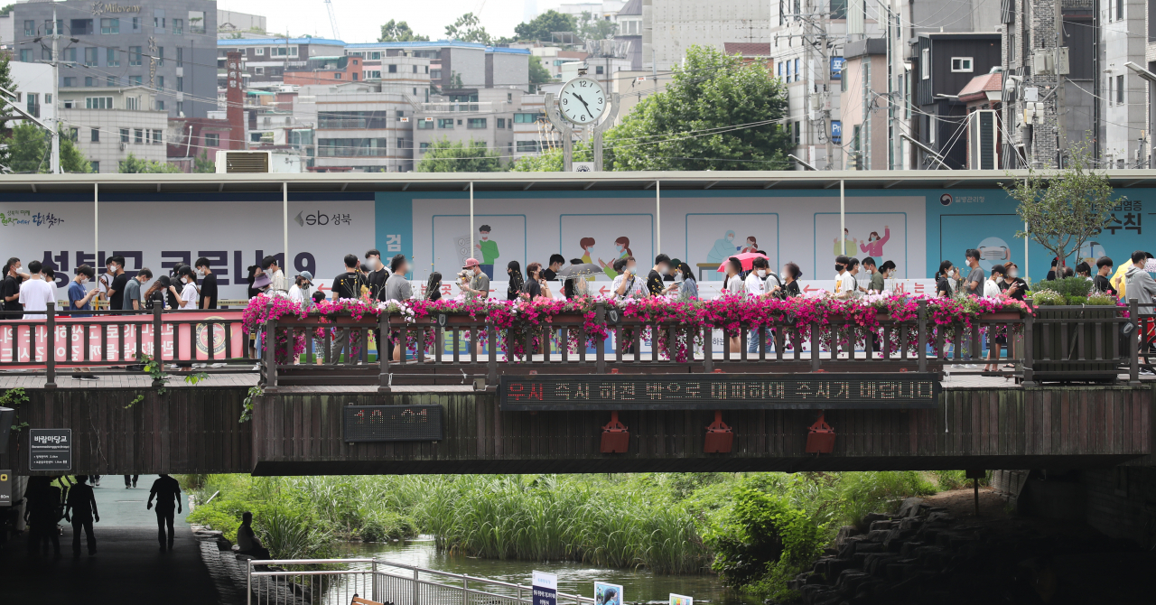 하루 코로나19 신규 확진자 수가 1200명을 넘어선 7일 오전 서울 성북구 임시 선별진료소에서 시민들이 검사를 위해 길게 줄지어 서 있다. [연합]