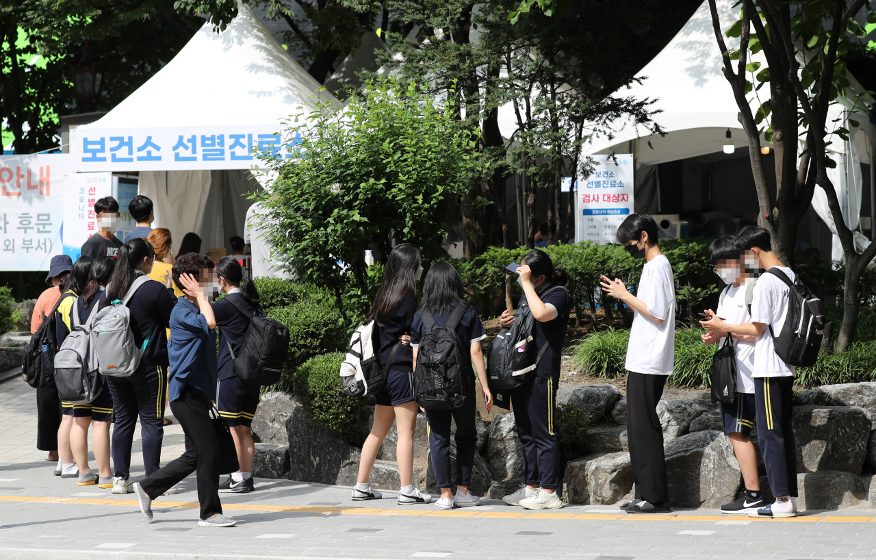 코로나19 신규 확진자 수가 1200명을 넘어선 7일 오전 서울 노원구 노원보건소 선별검사소에서 확진자와 밀접접촉한 사람들이 검사를 위해 길게 줄지어 서 있다. [연합]