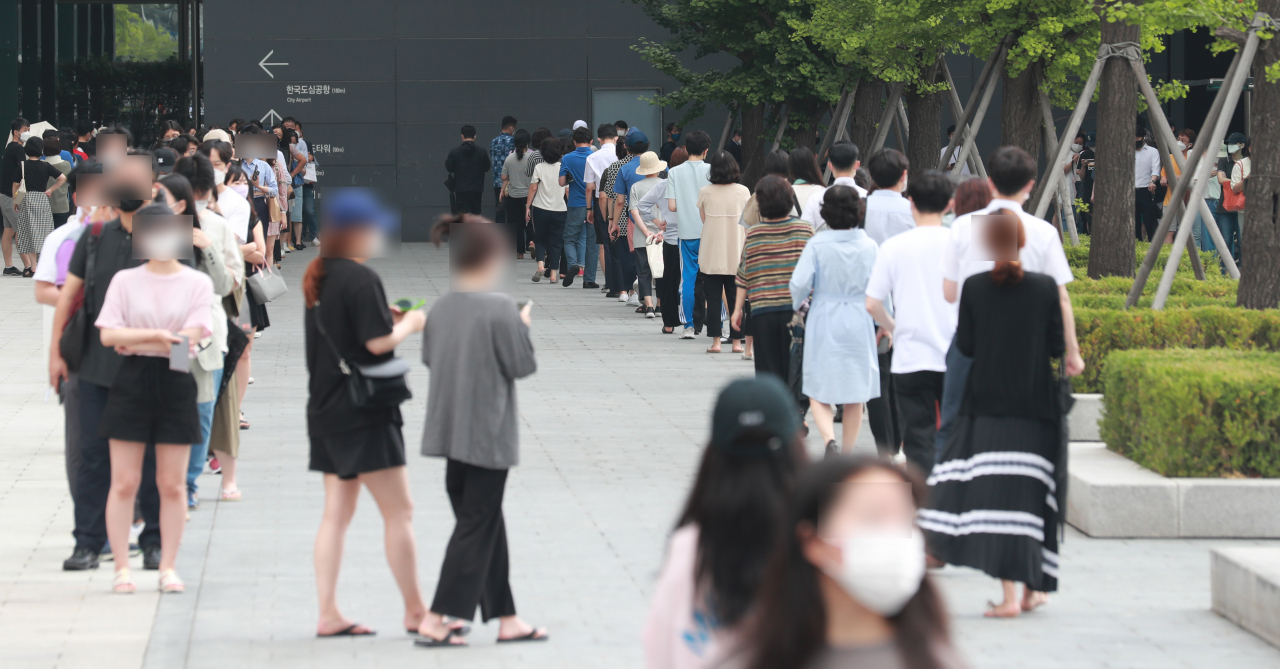 8일 서울 강남구 코엑스 인근 삼성역 앞에 설치된 임시 선별검사소를 찾은 시민들이 코로나19 검사를 위해 차례를 기다리고 있다. 중앙방역대책본부는 이날 0시 기준으로 신규 확진자가 1275명 늘어 코로나 사태 이후 가장 많은 수를 기록했다고 밝혔다. [연합]