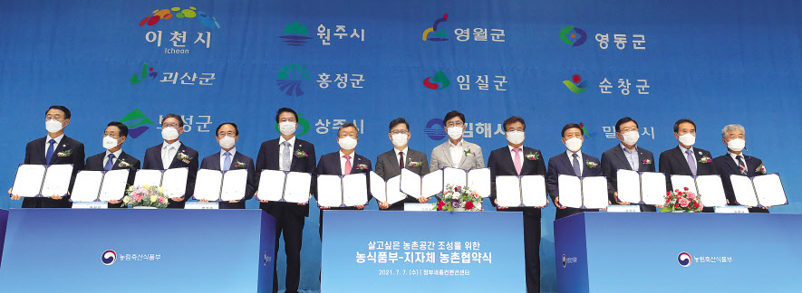 김현수 농림축산식품부 장관(왼쪽 일곱번째)을 비롯한 12개 시·군 지자체장들이 7일 오후 세종시 정부세종컨벤션센터에서 열린 살고 싶은 농촌 공간 조성을 위한 ‘농식품부-지자체 농촌 협약식’에서 협약서에 서명한 뒤 기념촬영을 하고 있다. [연합]