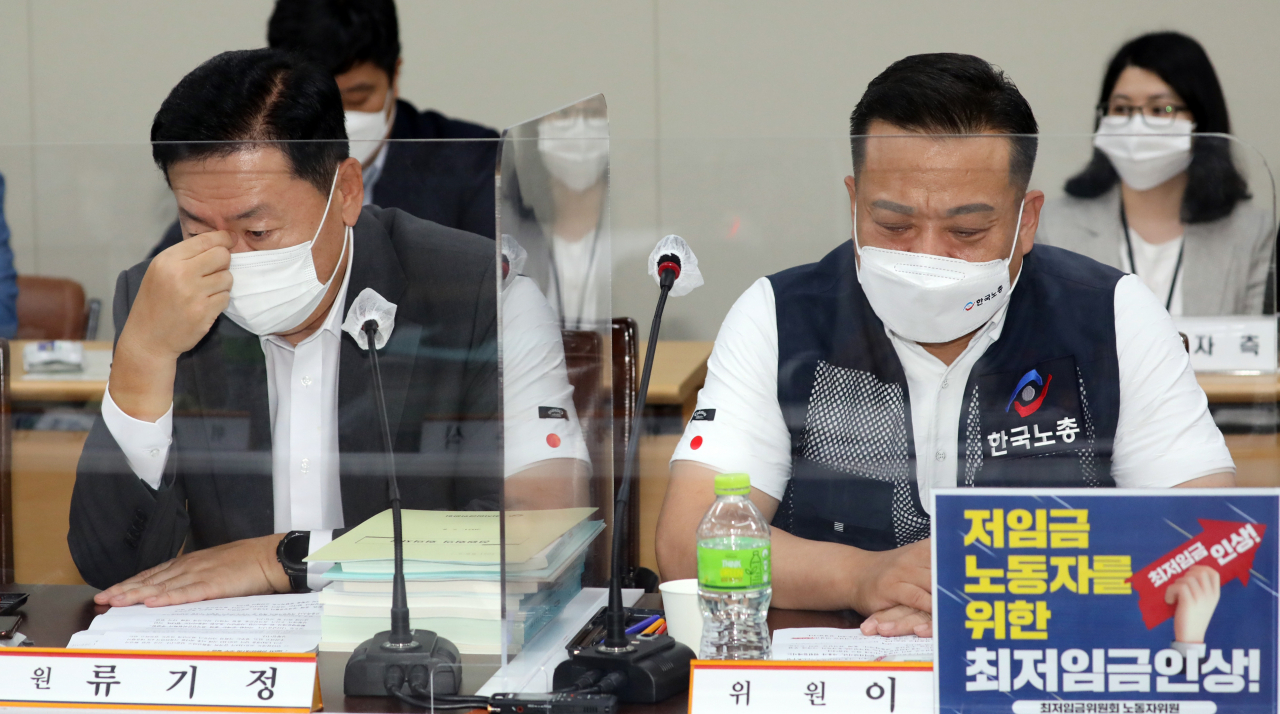 8일 오후 세종시 정부세종청사 최저임금위원회 회의실에서 열린 8차 전원회의에서 사용자위원인 류기정 경총 전무(왼쪽)와 근로자위원인 이동호 한국노총 사무총장이 고민하는 표정을 짓고 있다. [연합]
