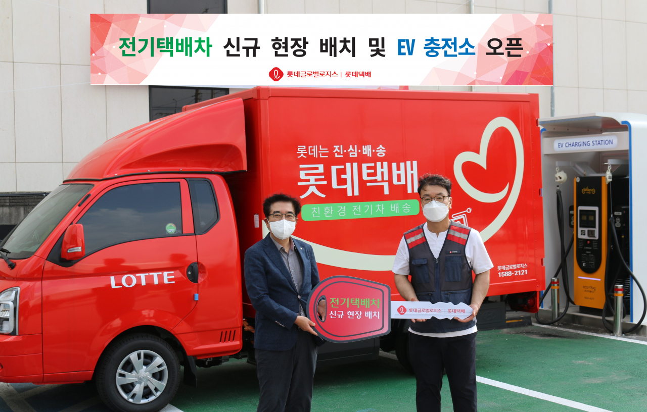 지난 8일 경기 남양주 소재 롯데택배 서울북부지점에서 안대준 롯데글로벌로지스 택배사업본부장(사진 왼쪽)이 택배기사에게 전기택배차를 인도하는 전달식을 갖고 있다. [롯데글로벌로지스 제공]