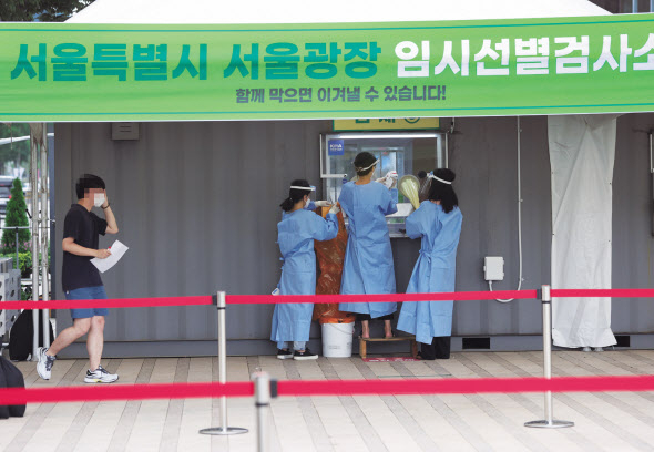 9일 오전 신종 코로나바이러스 감염증(코로나19) 확산세가 거세지면서 서울광장에 5개월 만에 다시 설치된 임시 선별검사소에서 관계자들이 분주히 움직이고 있다. [연합]