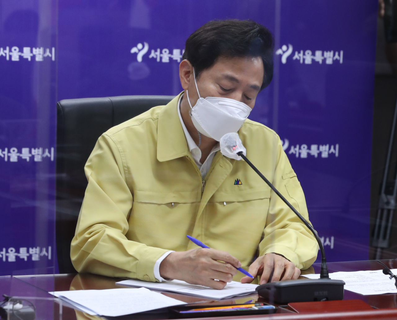 오세훈 서울시장이 8일 서울시청-자치구 간 영상회의로 열린 서울시·자치구 코로나19 특별방역대책회의에서 구청장들의 건의사항을 메모하고 있다. 연합뉴스