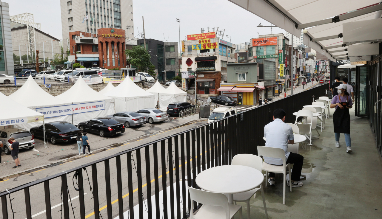 서울 신촌역 앞 야외 음식점 모습. 부근 선별진료소에서 시민들이 코로나19 검사를 받기 위해 대기해 있다. 연합뉴스