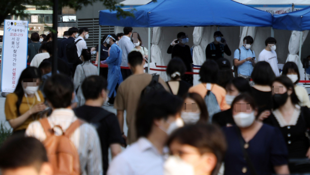 9일 저녁 강남역 임시선별진료소 앞으로 시민들이 지나가고 있다. [연합]