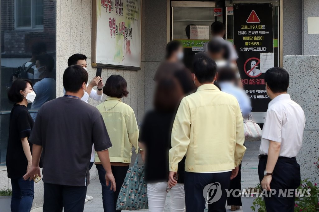 광주 개신교회 입구에서 종교시설 현장점검에 나선 공무원이 대면예배에 참석하는 신도들에게 집합금지 행정명령 준수를 당부하고 있다.