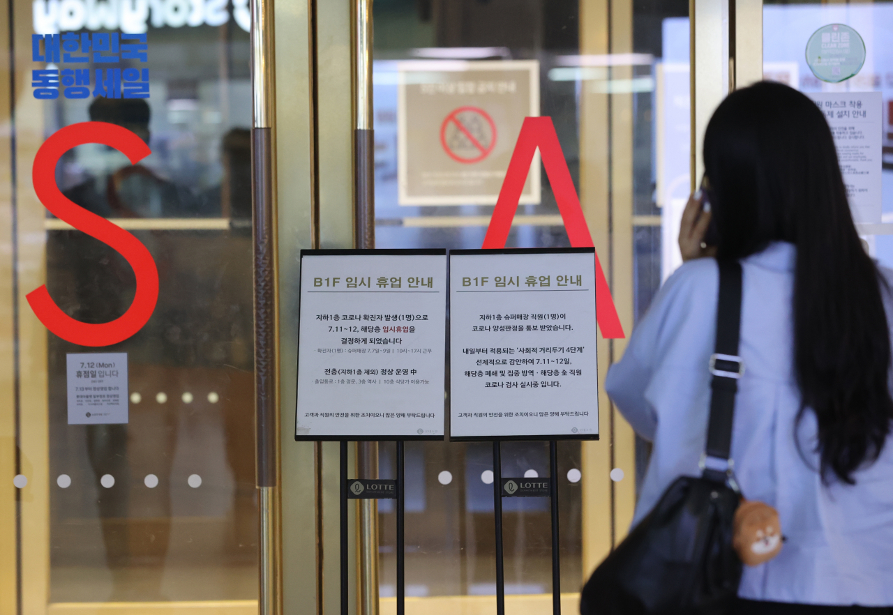11일 롯데백화점 서울 영등포점 지하 1층 슈퍼매장 근무자가 신종 코로나바이러스 감염증(코로나19) 확진 판정을 받음에 따라 지하 1층이 폐쇄돼 한 고객이 휴업 안내문을 보고 있다. [연합뉴스 제공]