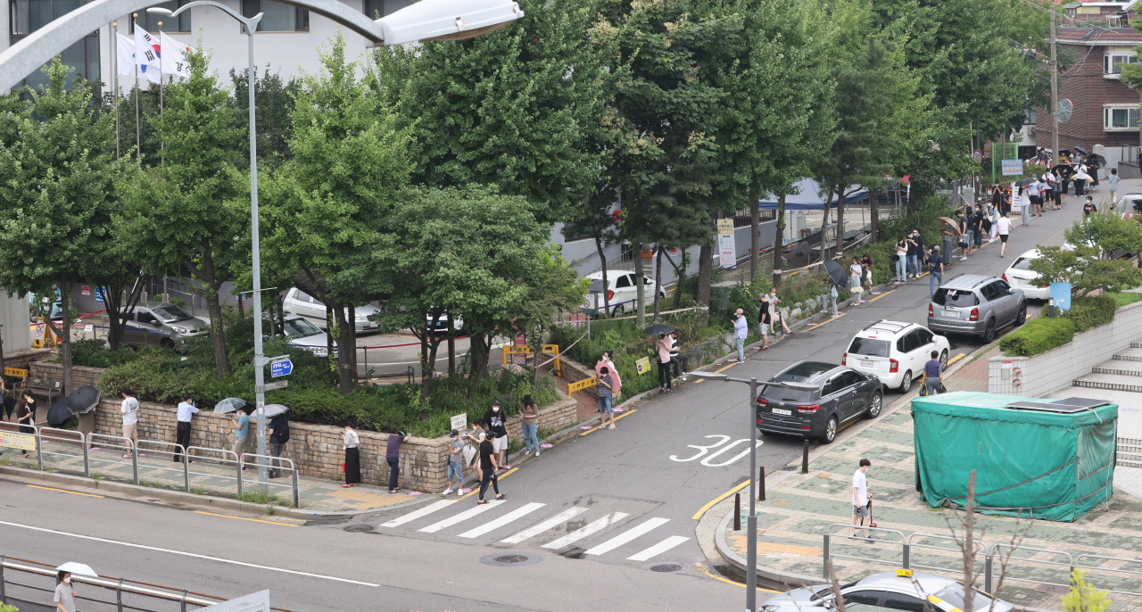코로나19 확진자 수가 연일 1000명대를 훌쩍 넘어선 가운데 11일 오후 서울 강서구보건소 선별진료소에서 검사를 받기 위해 시민들이 줄을 서 있다. [연합]