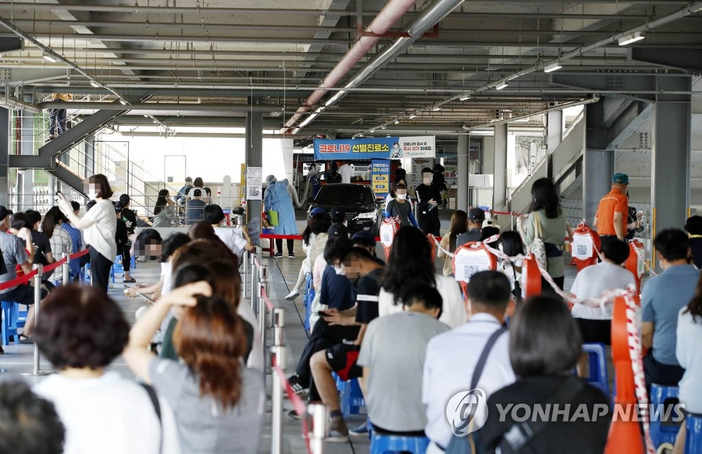 광주시청 야외음악당 광장에 마련된 선별진료소에서 시민이 코로나19 진단 순서를 기다리고 있다.
