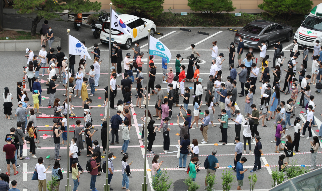 국내 신종 코로나바이러스 감염증(코로나19) '4차 대유행'이 확산하면서 신규 확진자 수가 엿새 연속 1000명을 넘어 네 자릿수를 기록한 12일 오전 서울 강남구 보건소 선별진료소에서 시민들이 검사를 받기 위해 줄을 서고 있다. [연합]