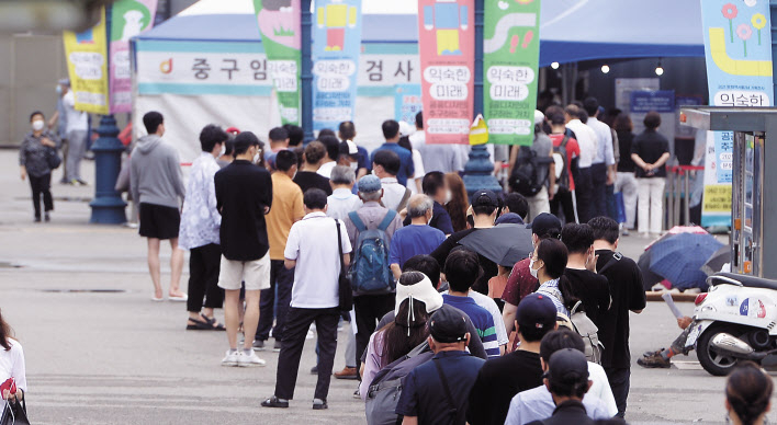 코로나19 확진자수가 엿새째 1000명대를 넘긴 가운데 12일 오전 서울 중구 서울역 인근에 마련된 임시선별진료소에서 시민들이 검사를 받기 위해 길게 줄을 서있다. 이상섭 기자