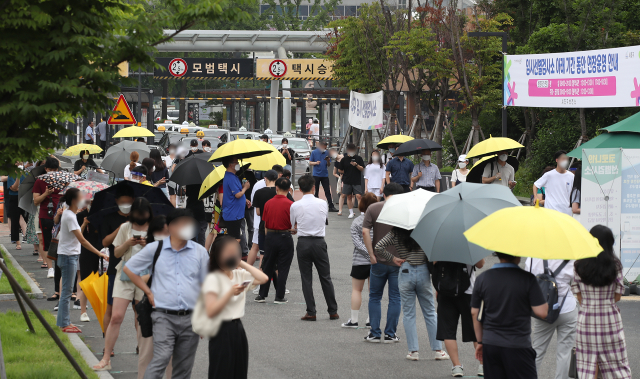 국내 코로나19 ‘4차 대유행’이 확산하면서 신규 확진자 수가 엿새 연속 1000명을 넘어 네 자릿수를 기록한 12일 오전 서울 서초구 고속터미널 임시 선별검사소에서 시민들이 검사를 기다리며 줄지어 서 있다. [연합]