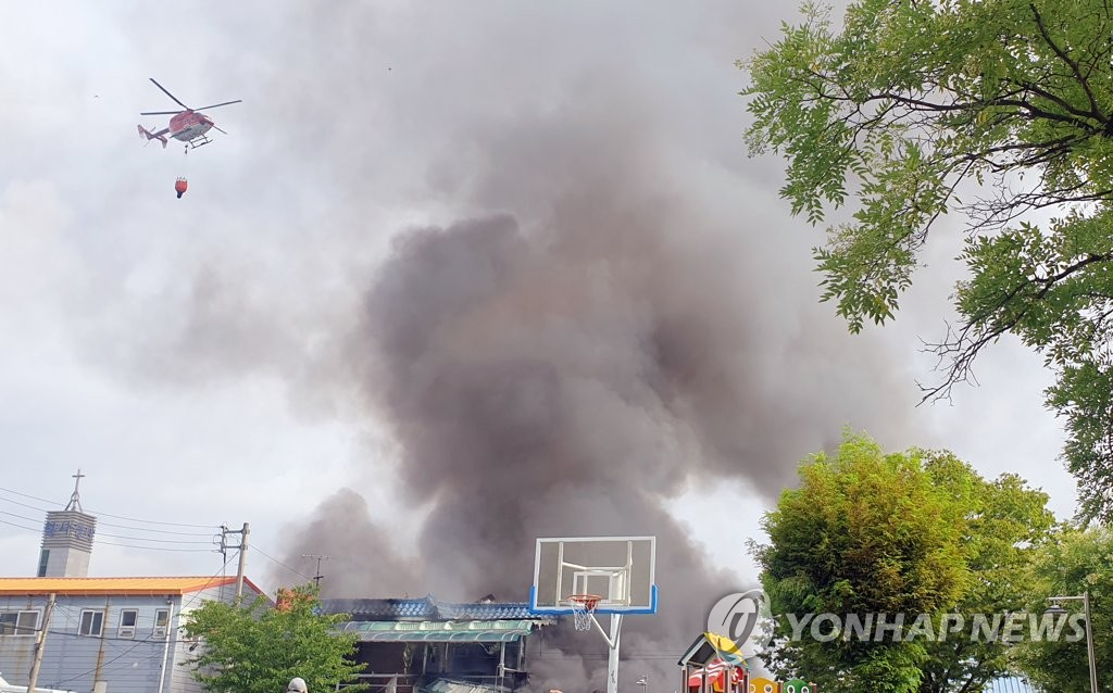12일 오전 광주 광산구 우산동 한 생활용품 창고에서 불이나 소방당국이 헬기를 동원해 진화 작업을 하고 있다.
