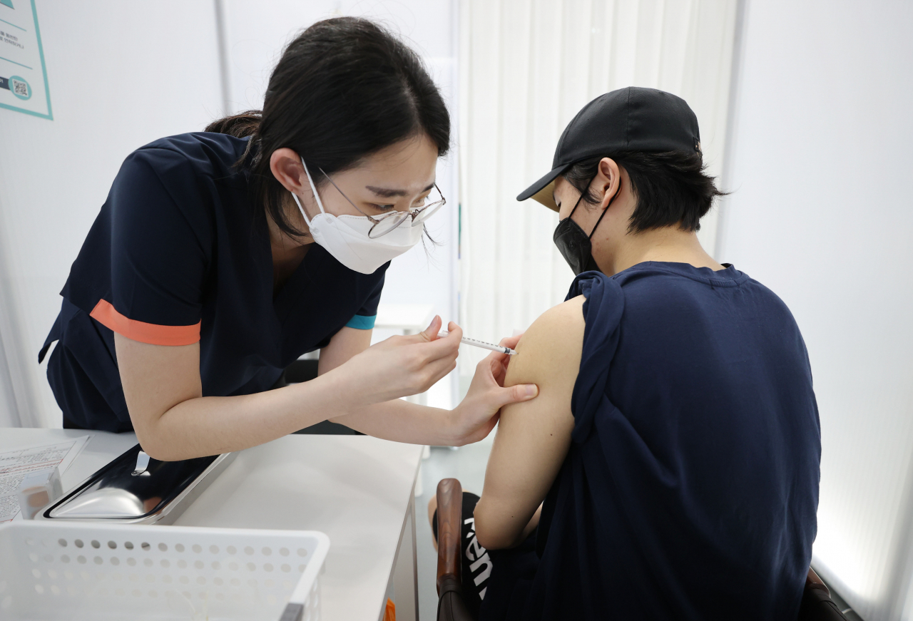 12일 오후 서울 동작구민체육센터에 마련된 코로나19 예방접종센터에서 7&sim;9월 현역병 입영 예정자가 화이자 백신을 접종하고 있다. [연합]
