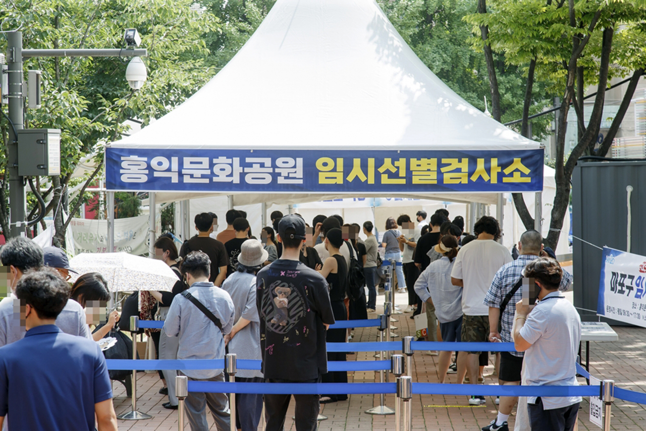 서울 마포구가 수도권 코로나19 확산 방지를 위한 특별방역대책에 따라 임시선별검사소를 추가 설치했다고 12일 밝혔다. 사진은 홍익문화공원 임시선별검사소 앞 대기하는 시민들. [연합]