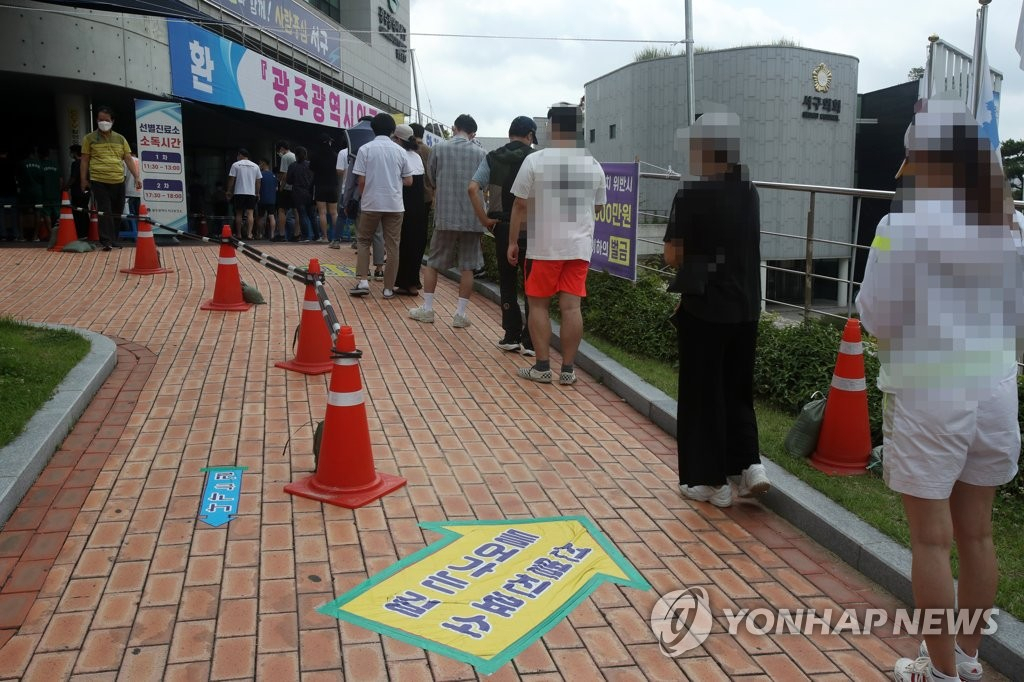 광주 서구 보건소 선별 진료소에서 코로나 19 검사를 받으려는 시민들이 줄 서 있다.