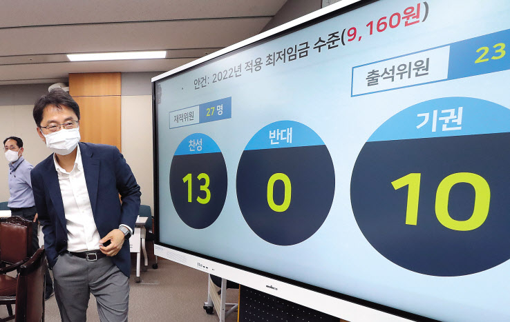 박준식 최저임금위원회 위원장이 12일 밤 제9차 전원회의에서 내년도 최저임금을 9160원으로 의결한 뒤 위원들과 인사하기 위해 이동하고 있다. [연합]