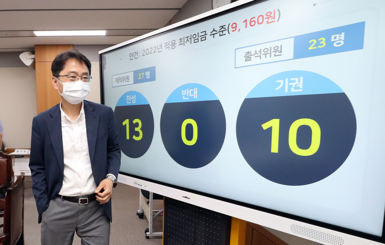 Park Joon-shik, head of the Minimum Wage Commission, exits a press conference at the government complex in Sejong on early Tuesday morning after completing negotiations for next year‘s minimum wage rate. The commission voted 13-0 to pass a proposal to set next year‘s minimum hourly wage at 9,160 won. (Yonhap)