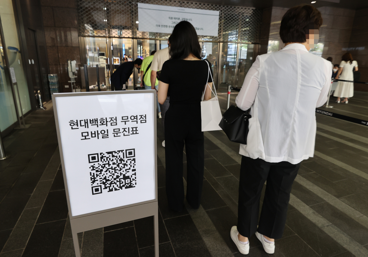 신종 코로나바이러스 감염증(코로나19) 집단감염이 발생해 1주일가량 휴점했던 서울 삼성동 현대백화점 무역센터점이 영업을 재개한 13일 오전 모바일 문진표를 작성한 관계자들이 백화점으로 향하고 있다. [연합]