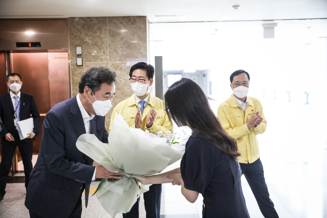 더불어민주당 대선 경선을 치르고 있는 이낙연 후보가 13일 충남도청을 찾아 꽃을 전달받고 있다. 가운데는 양승조 충남지사. [연합]
