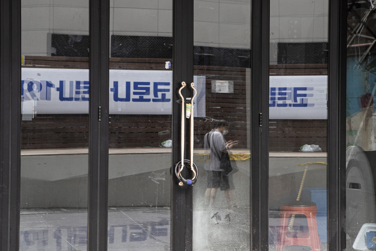 수도권 전체에 '사회적 거리두기' 4단계가 적용되고 있는 13일 서울시 용산구 이태원에서 '코로나19 아직 끝나지 않았습니다'라고 적힌 현수막이 문 닫은 식당의 창문에 투영되고 있다. 연합뉴스
