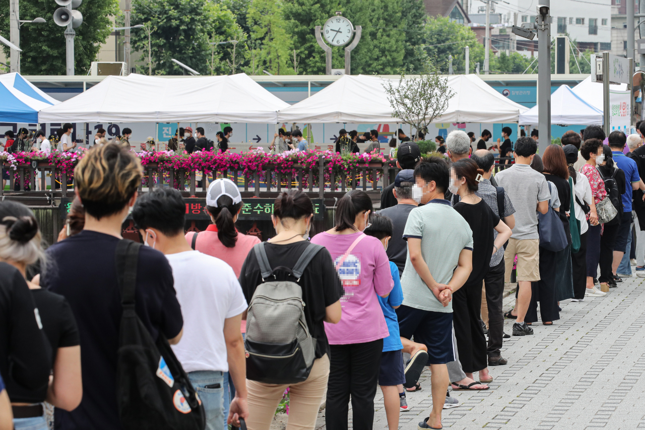 13일 오전 서울 성북구 돈암동 성북천 변에 마련된 임시선별검사소에 코로나19 검사를 받으려는 시민들[연합]
