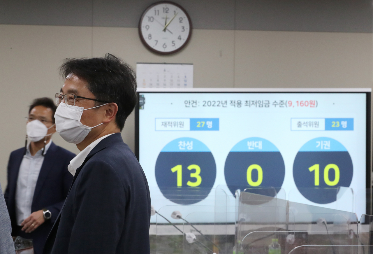박준식 최저임금위원회 위원장이 지난 12일 밤 제9차 전원회의에서 내년도 최저임금을 9160원으로 의결한 뒤 위원들과 대화하고 있다. [연합]