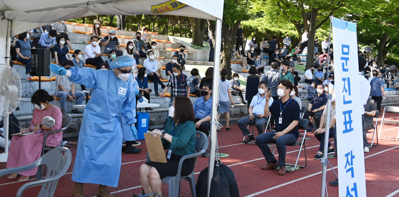 15일 오전 서울 여의도 국회 운동장에 마련된 임시선별검사소에서 국회 직원 등 상주 근무자들이 코로나19 검사를 받기 위해 번호표를 뽑고 대기하고 있다. 연합뉴스