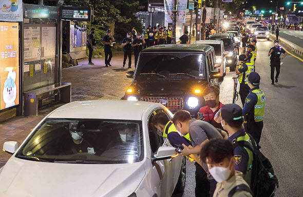 15일 새벽 전국자영업자비대위 소속 회원 등이 서울 종로구 마로니에공원 일대에서 비상등을 켠 채 정부의 ‘거리두기 4단계 조치’에 불복하는 1인 차량 시위를 하고 있다. [연합]