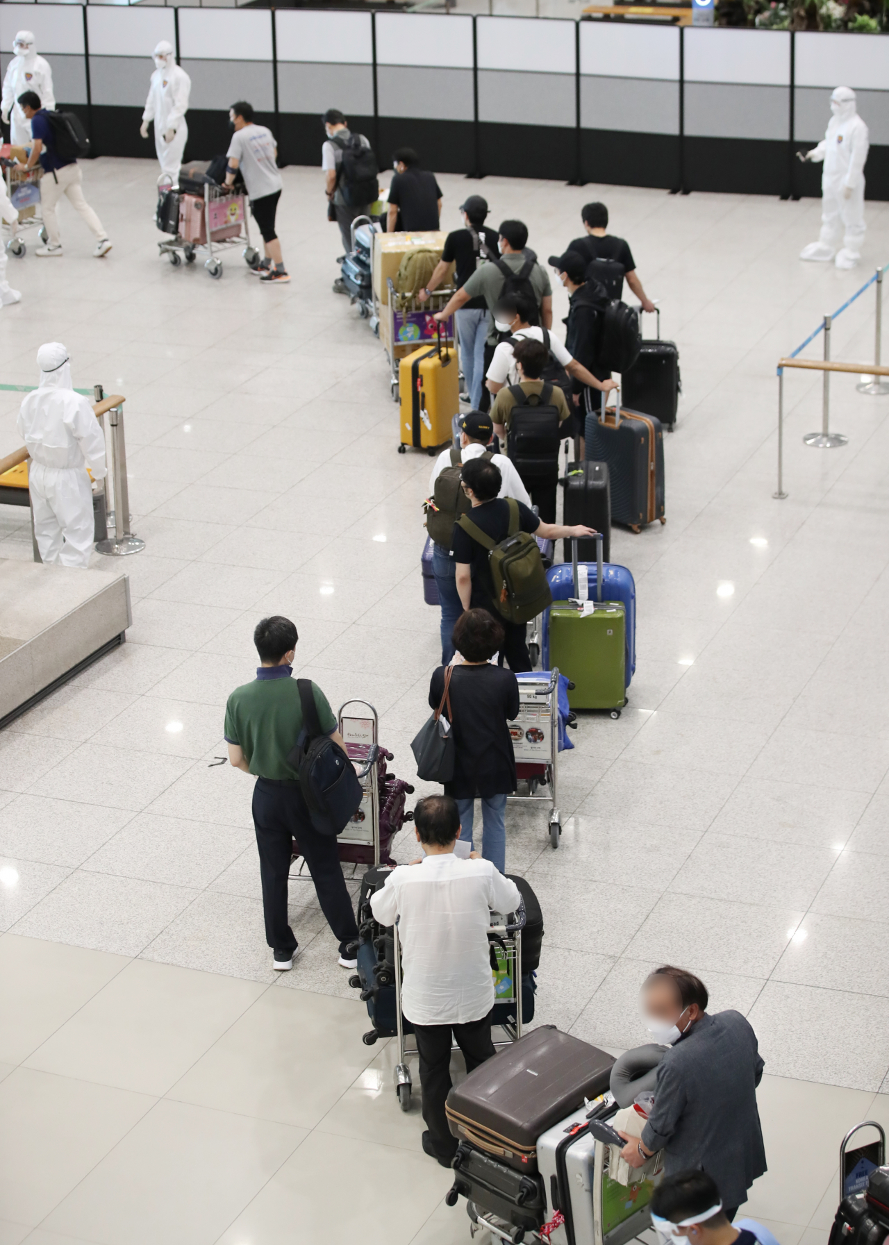 코로나19 '4차 대유행'이 본격적으로 확산하고 있는 가운데 지난 13일 오전 인천국제공항 제1터미널에서 인도 첸나이에서 온 교민과 주재원들이 방역 관계자의 안내를 받아 이동하고 있다. [연합]