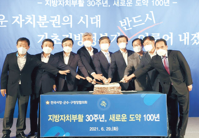 송영길 더불어민주당 대표가 지난달 2일 국회 의원회관에서 열린 민주당 재정분권특별위원회 당·정·청 전체회의에서 김영배 재정분권특위원장 등 참석자들과 기념촬영을 하고 있다(윗쪽). 전국시장·군수·구청장협의회가 지난달 29일 서울가든호텔에서 열린 민선 7기 3차년도 제4차 공동회장단 회의에서 지방자치 부활 30주년을 축하하는 떡 케이크 퍼포먼스를 하고 있다. [연합]