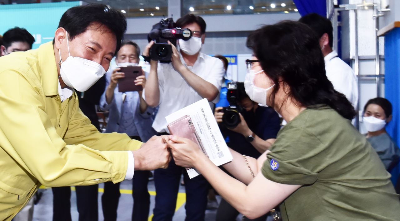 델타변이 등 코로나19 바이러스 수도권 확진자 수가 급증하는 가운데 15일 서울 마포구 예방접종센터를 찾은 오세훈 서울시장이 시민들과 인사를 나누고 있다. 연합뉴스