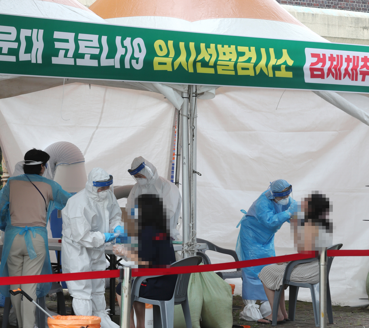 지난 16일 오후 부산 해운대구 옛 해운대역 광장에 마련된 임시선별검사소에서 시민들이 신종 코로나바이러스 감염증(코로나19) 검사를 받고 있다. [연합]