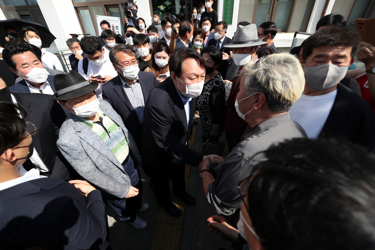 대선 출마를 선언한 윤석열 전 검찰총장이 17일 오후 5·18민주화운동 역사 현장인 광주 동구 옛 전남도청 별관을 방문한 뒤 주변에 모여든 지지자들과 악수하고 있다. [연합]