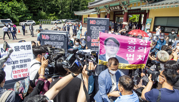 윤석열 전 검찰총장이 17일 광주 5.18 민주 묘지를 참배한 가운데 지지자들과 비판단체가 충돌하고 있다.