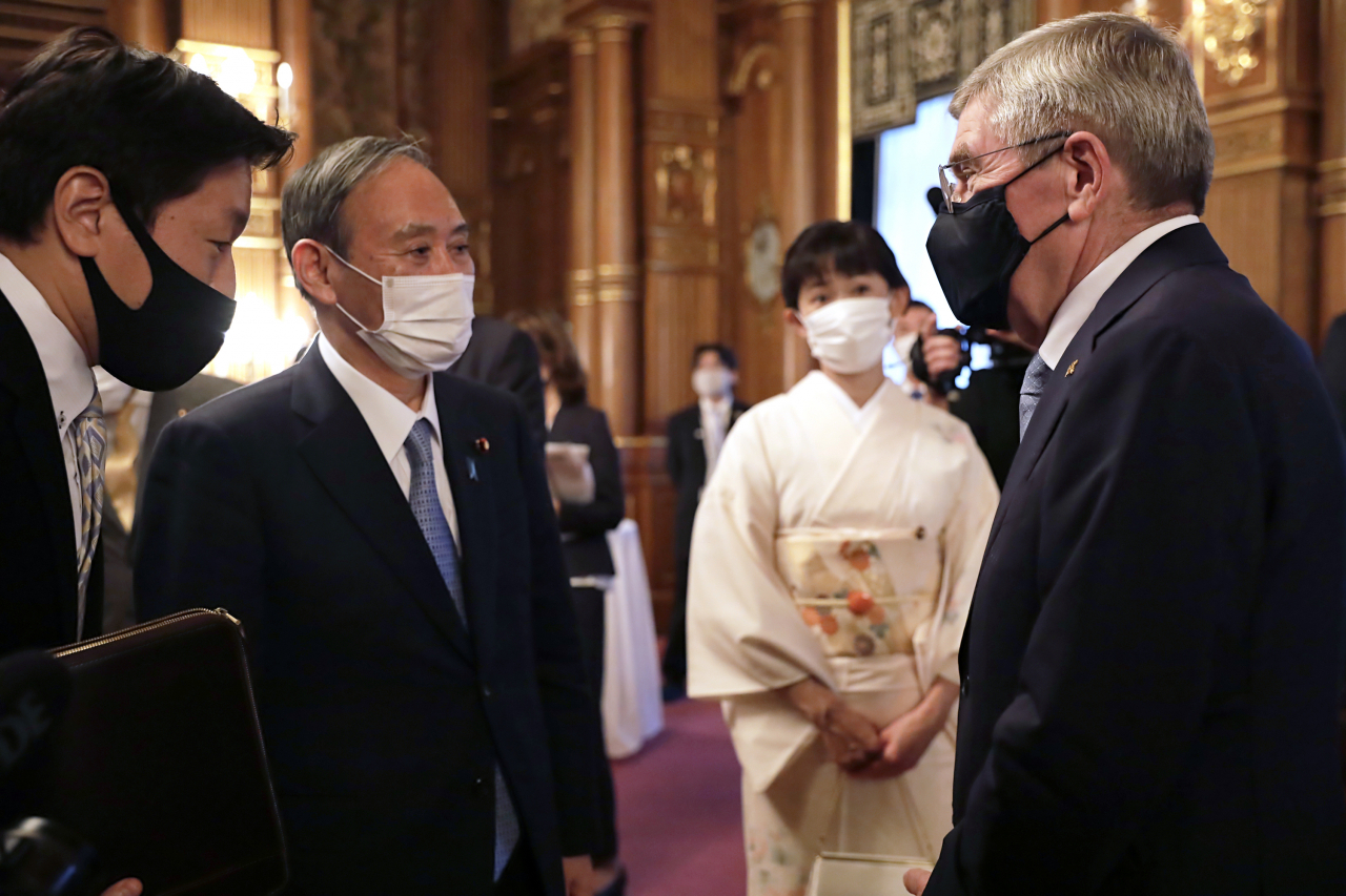 스가 요시히데(菅義偉·왼쪽 두 번째) 일본 총리가 18일 오후 도쿄 모토아카사카(元赤坂) 영빈관(아카사카 별궁)에서 개최된 국제올림픽위원회(IOC) 간부진 환영 행사에서 토마스 바흐(오른쪽 첫 번째) IOC 위원장과 인사를 나누고 있다. [AP]