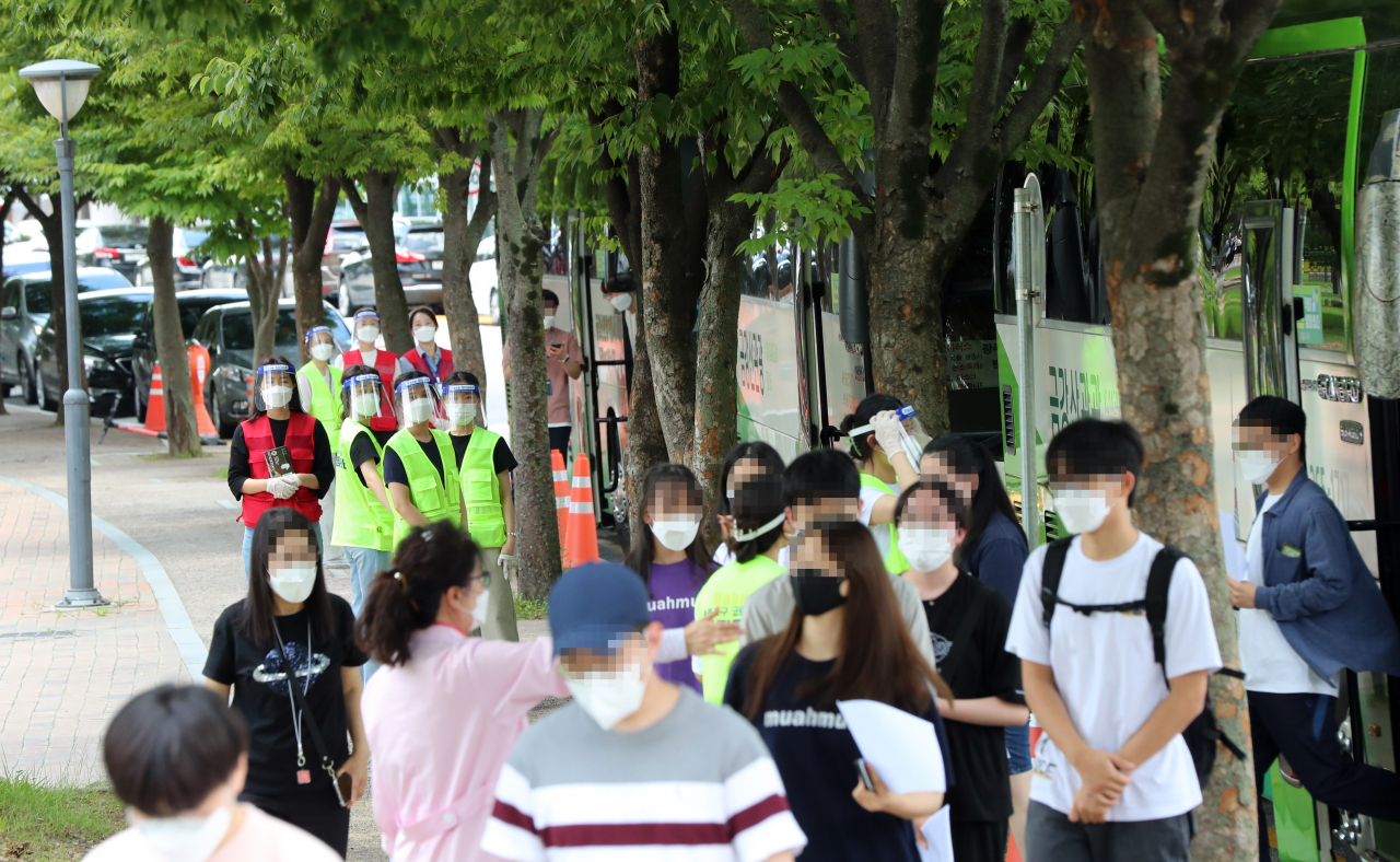 19일 오후 광주 북구 예방접종센터 앞에 화이자 코로나19 백신을 접종받기 위해 찾은 고등학교 3학년과 교직원들이 차에서 내리고 있다. [연합]