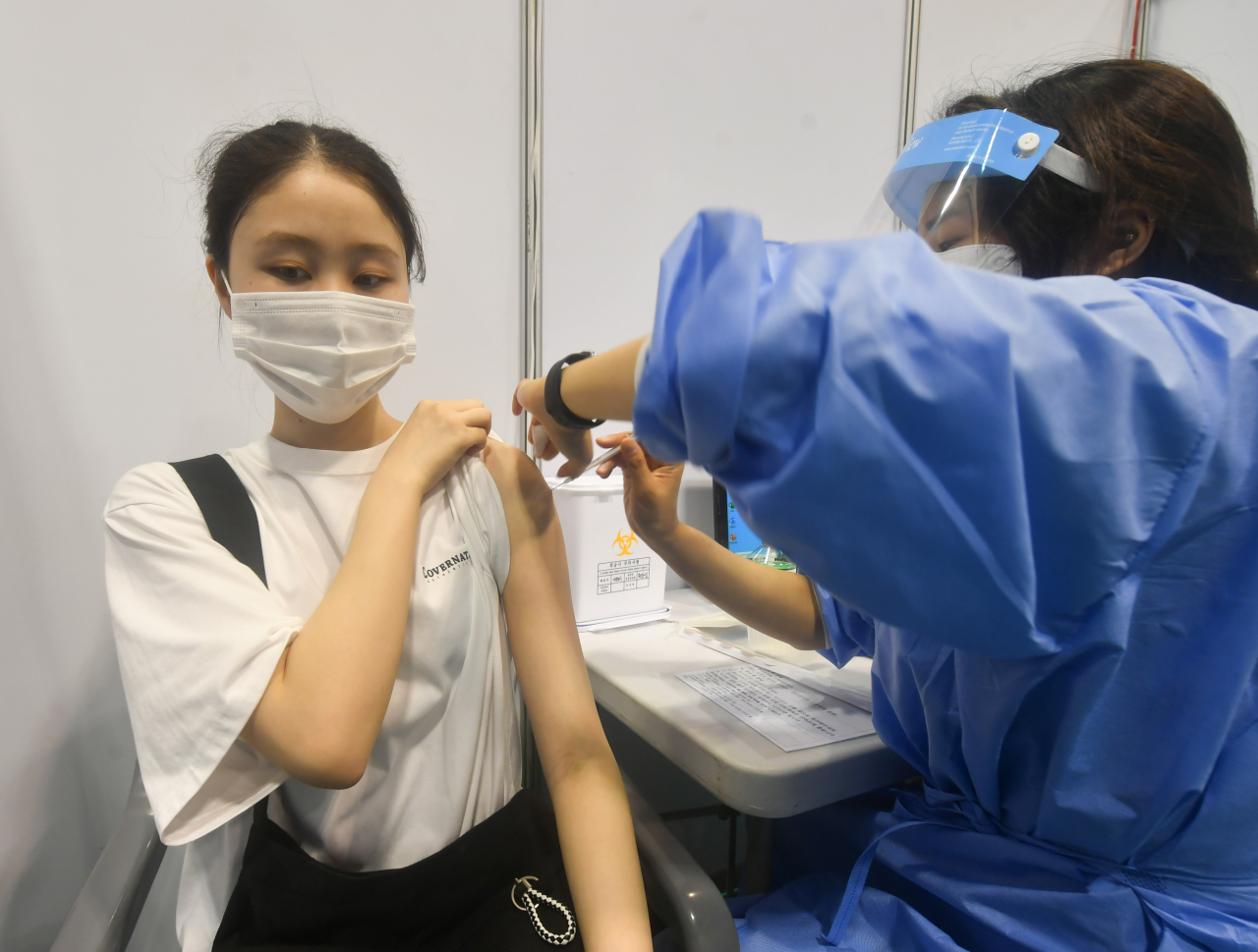 고등학교 3학년 학생 및 교직원 등에 대한 백신 접종이 시작된 19일 오전 경기도 수원시 영통구 아주대학교 체육관에 설치된 수원시 코로나19 예방접종센터에서 고3 학생이 화이자 백신을 접종받고 있다. [연합]