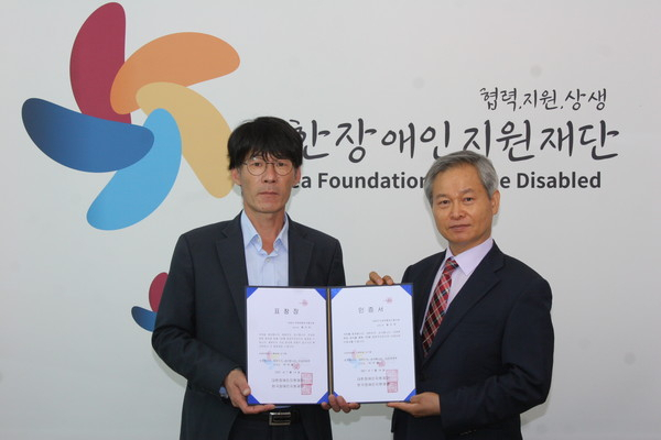 표창을 받은 황진택 전 서해대 총장이 시상자인 박우철 대한장애인지원재단 회장 겸 선정위원장과 기념촬영하고 있다. [장애인지원재단 제공]