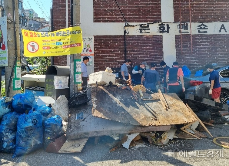 동주민센터 직원과 주민, 공공근로 잠여자들이 무단 폐기물을 치우고 있다. [서대문구 제공]