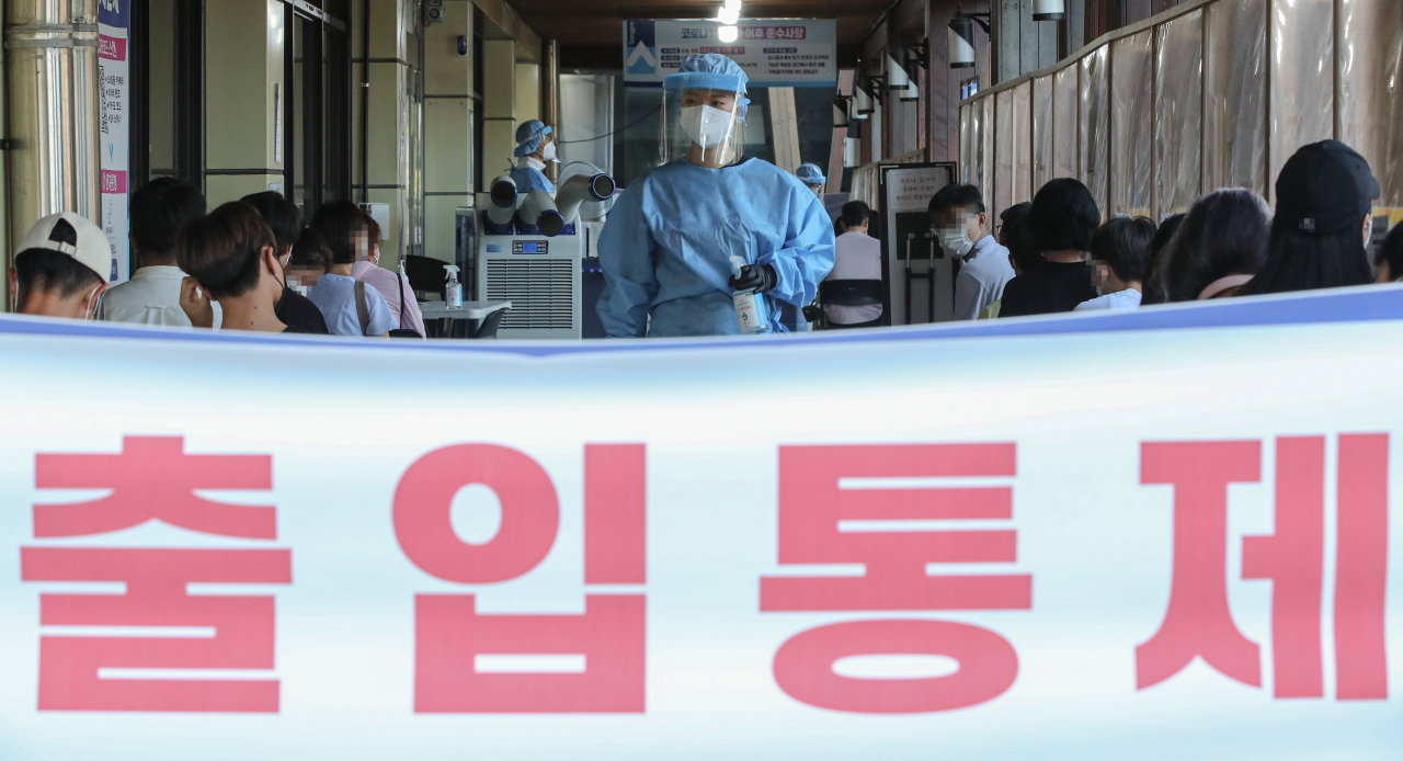 코로나19 신규 확진자가 1784명을 기록해 1주 만에 최다 기록을 갈아치운 21일 오전 서울 송파구 송파구보건소에 마련된 선별진료소에서 관계자가 방호복을 입고 시민들을 안내하고 있다. [연합]