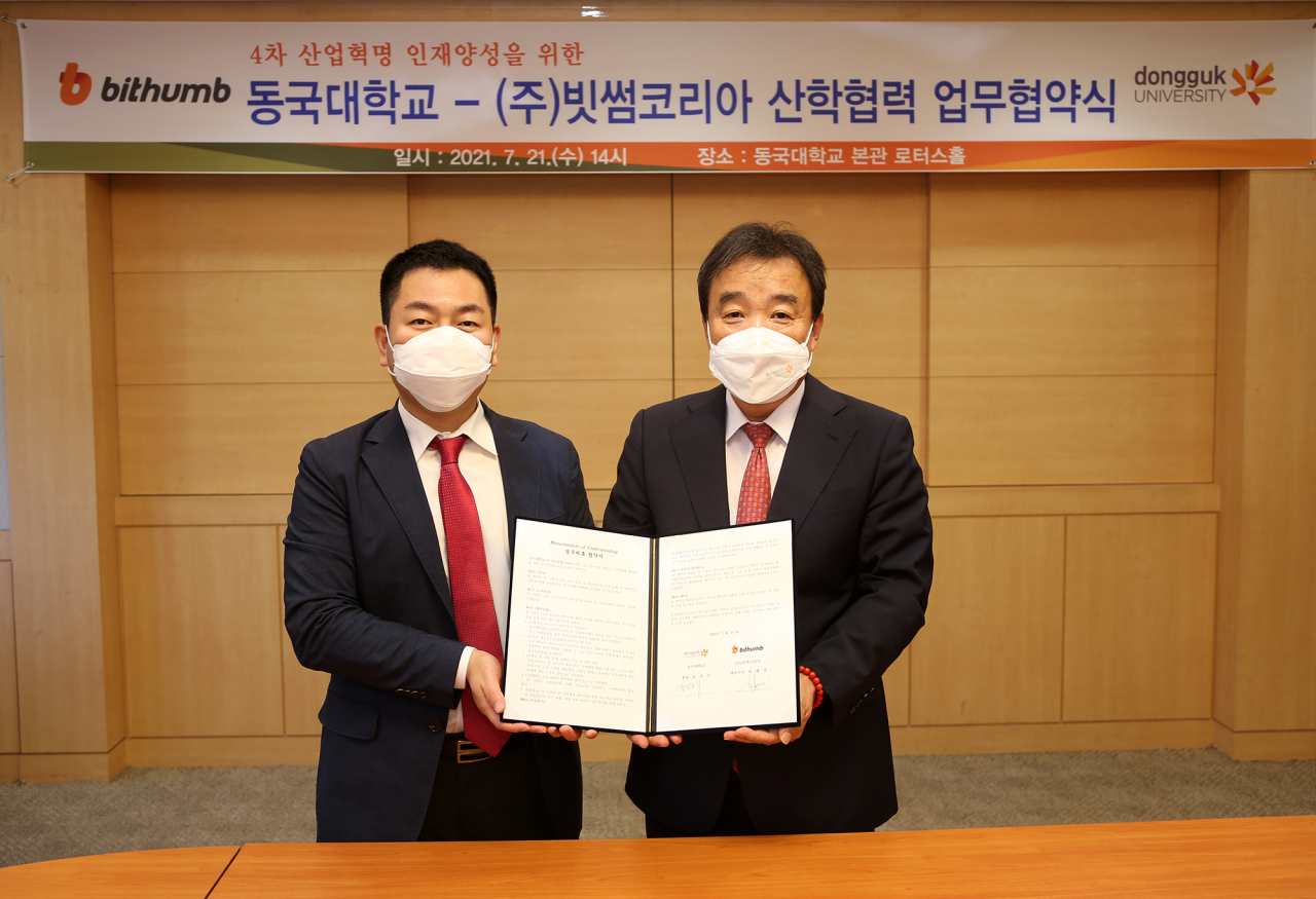 허백영 대표(왼쪽)와 윤성이 총장이 21일 오후 동국대 본관 4층 로터스롤에서 MOU 체결 후 기념 촬영을 하고 있다.[빗썸 제공]