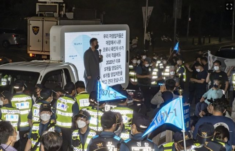 지난 14일 밤 서울 여의도공원 인근에서 열린 '전국자영업자비대위, 거리두기4단계 조치 불복 기자회견'에서 국민의힘 최승재 의원이 발언하고 있다. [연합]
