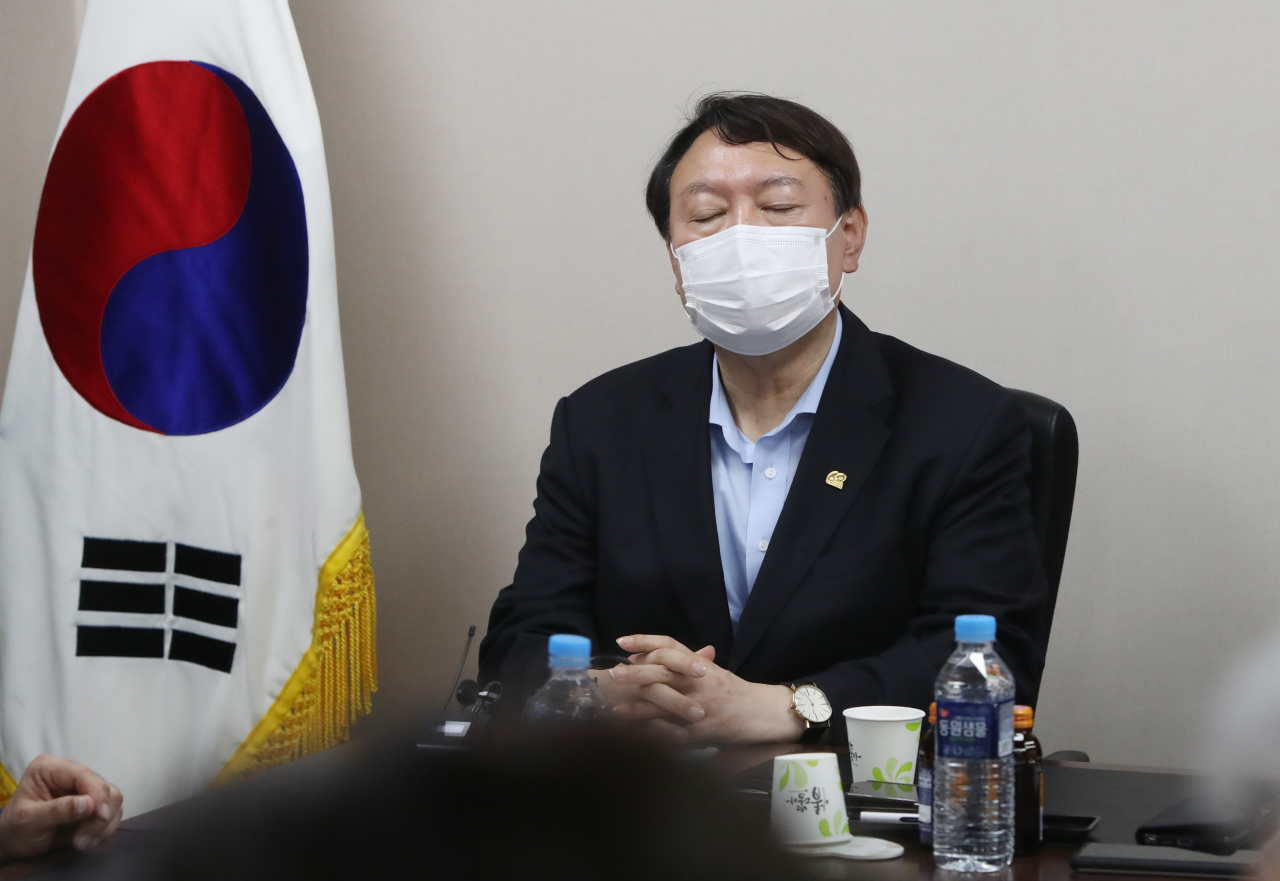 대선 출마를 선언한 윤석열 전 검찰총장이 20일 오후 대구 중구 서문시장을 찾아 상인회 관계자들과 얘기를 나누다가 잠시 생각에 잠겨 있다. [연합]