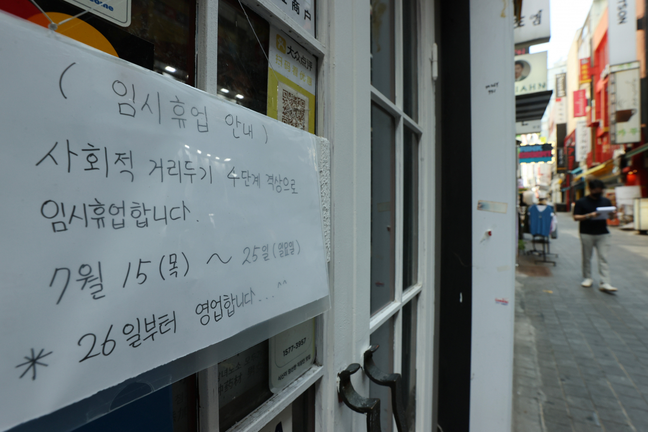 지난 21일 오후 서울 중구 명동의 한 가게에 사회적 거리두기 4단계 격상으로 인한 임시휴업 안내문이 붙어있다.[연합]