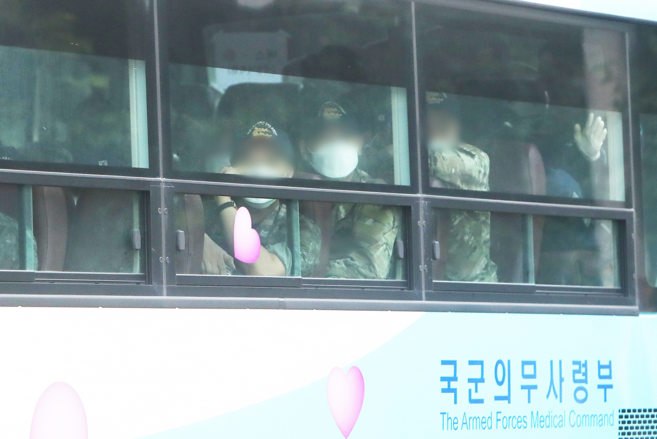 코로나19 집단감염으로 국내 복귀한 뒤 분산 격리돼 치료를 받고 있는 청해부대 34진 문무대왕함(4400t급) 장병들은 일부 언론 보도와 달리 “피가래를 토하는 인원들은 보지 못했다”고 입을 모았다. 청해부대 장병들이 지난 20일 복귀해 국방어학원 생활치료센터로 들어가고 있다. [연합]
